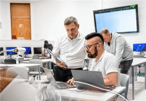 Michael Reupert mit Mitarbeiter Markus Mann im Gespräch. Im Hintergrund Maximilian Schubert. Foto Chiemgau GmbH