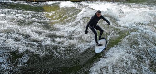 Surfer auf der Surfwelle des Eisbachs im Englischen Garten in München: Ein optimaler Standort in Rosenheim für eine vergleichbare Welle könnte in Rosenheim der Hammerbach auf Höhe des Ichikawa-Platzes sein. Foto Imago/Eibner
