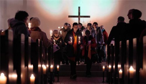 Die Macht der Liebe im Fokus: Teilnehmer eines Taize-Gottesdienstes, Menschen unterschiedlicher Konfession, beten gemeinsam für den Weltfrieden und tragen ein Licht als Symbol der Hoffnung hinaus in die Welt. Foto dpa