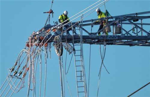 Monteure arbeiten in luftiger Höhe an der Fertigstellung einer Stromtrasse. Foto dpa