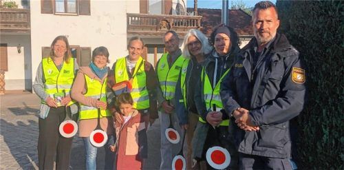 Polizeibeamter Andre Pust (rechts) weist freiwillige Eltern als Schulweghelfer ein. Foto Bettinger