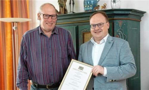 Bürgermeister Andreas Friedrich (rechts) überreicht Georg Kaiser eine Jubiläumsurkunde. Foto  Berger