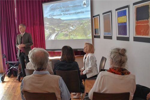Bürgermeister Andreas Scheck (hinten) zeigt die Historie des Ortes anhand von Bildern. Foto  Wunderlich