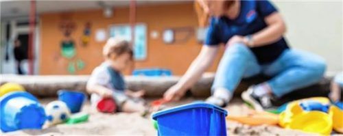 Ein Kind spielt mit einer Erzieherin im Sandkasten. Foto dpa