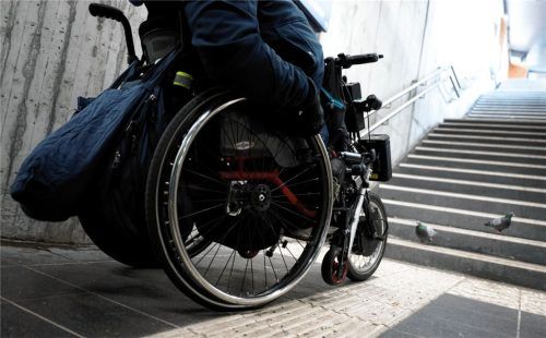 Ein Mann steht mit seinem Rollstuhl an einer Treppe (Symbolbild). Foto dpa