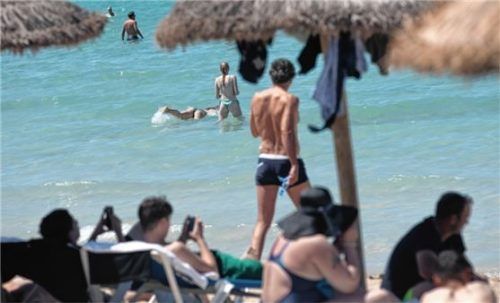 Menschen schwimmen und sonnen sich am Strand von Arenal auf Mallorca. Foto dpa