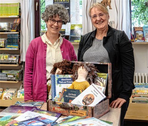 Pastoralreferentin Martina Mauder und Oberaudorfs Büchereileiterin Karin Obwieser sind überzeugt: Die Bücher im „Trostkoffer“, den es ab sofort auszuleihen gibt, und auch sein Begleiter, der Trösteengel Charlie, können das Gespräch mit Kindern über das Thema Tod erleichtern.Foto thomae