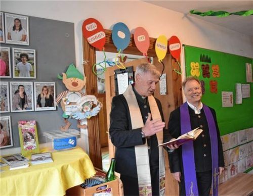 Pfarrer Martin Straßer (links) und Rainer Maier segnen die Kinder und den Kindergarten. Foto  Wunderlich