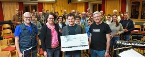 Scheckübergabe: (von links) Georg Leidel (Beisitzer), Barbara Dienhart (Vorsitzende), Thomas Grill (Neon Rosenheim) und Dirigent Albert Osterhammer bei der symbolischen Überreichung der 1900 Euro. Foto Berger