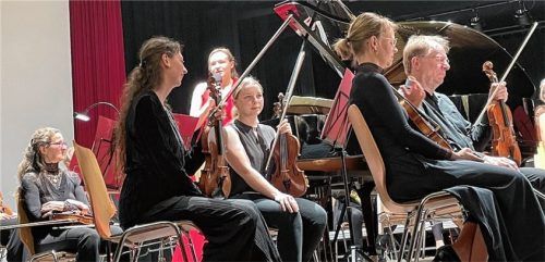 Solistin Kathrin Isabella Klein (im roten Kleid) spielte inmitten des Orchesters beim Klavierkonzert a Moll op. 54 von Robert Schumann. Genau so, wie es schon Schumanns Frau Clara bei der Uraufführung gesagt hatte: „Das Klavier ist auf das Feinste mit dem Orchester verwebt – man kann sich das eine nicht denken ohne das andere.“Foto kirchner