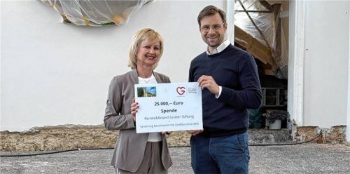 Pfarrer Richard Graupner nimmt einen Scheck von Irmgard Hutter-Nicolosi entgegen. Foto RE