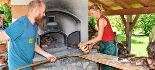 Christian und Melanie Wimmer holen die Brote aus dem Holzbackofen. Foto  Wunderlich