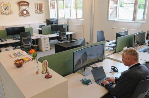 Der Arbeitsplatz des Bürgermeisters im Großraum-Büro – im Hintergrund die Wappen von Bruckmühl (Mitte) und der beiden eingemeindeten Kommunen Holzham (links) und Götting. Fotos Baumann