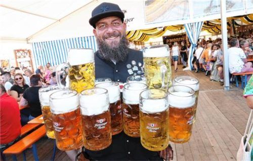 Ein Lächeln trotz der über 30 Kilogramm Gewicht, die die Bierkrüge locker zusammenbringen.