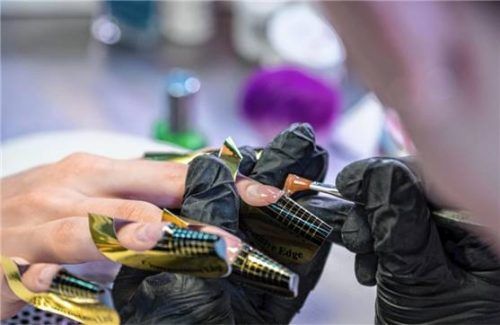 Eine Kosmetikerin trägt in einem Nagelstudio eine Gelschicht auf die Nägel einer Kundin auf (Symbolbild). Foto picture alliance/Christin Klose