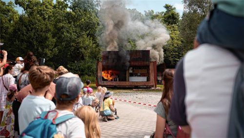Mit gebührendem Sicherheitsabstand und großen Augen verfolgen die Besucher die Fettbrand-Demonstration.Foto re
