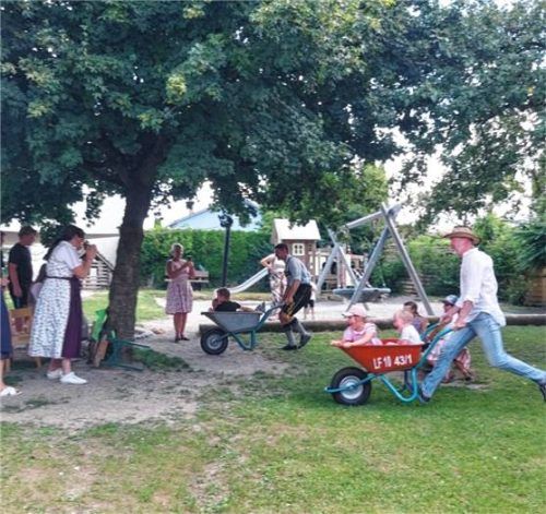 Schwer beladen mit lachenden Kindern lieferten sich die Väter ein Schubkarrenrennen.Foto re