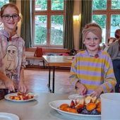 Zwei Dutzend Kinder kochen Marmelade ein