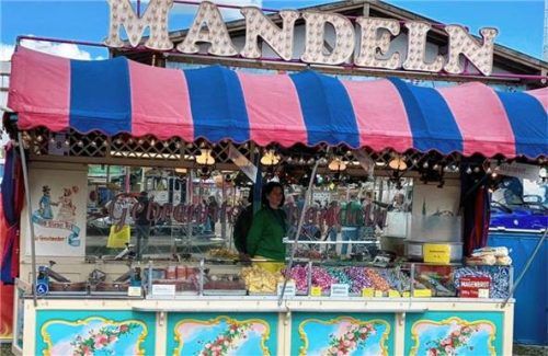 Den alten Stand mit der charakteristischen rot-blau gestreiften Plane über dem Runddach hat Helmut Zehle eigenhändig gebaut. Er wurde vor zwölf Jahren durch einen neuen Verkaufsstand mit handgemalten Rosenheimer Motiven ersetzt. Fotos re