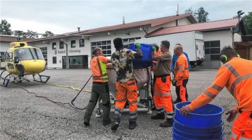 Der Helikopter wartet auf die Befüllung des Streubehälters mit Bti-Eisgranulat, das die Mitarbeiter vom Bauhof Chieming, von der Firma ICEIBAC, von KAPS und vom AUV vom Sattelschlepper erst in Eimer füllen mussten.Foto Dachs