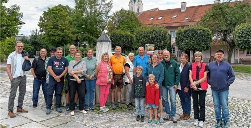 Die Gruppe um Peter Fenzl (Bildmitte, im blauen Hemd), der auf einer Bildtafel ein historisches Bild zeigt.Foto Voit