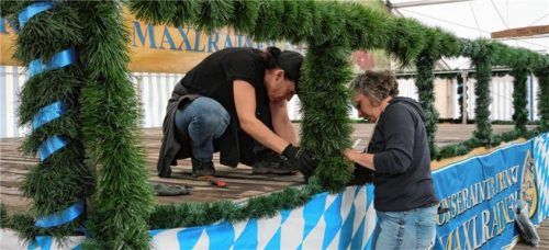 Die Musikerbühne zu schmücken ist beim Volksfest Präzisionsarbeit. Foto Merk
