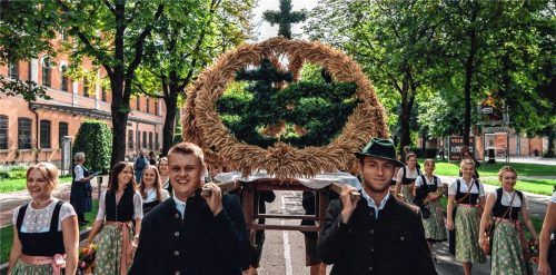 Große Ehre: Die Burschen der KLJB Vogtareuth tragen ihre handgefertigte „Grüne Erntekrone“ stolz beim Kirchen- und beim Festzug. Die Dirndl umrahmen die Krone mit schönen Blumengirlanden. Foto Wirtschaftlicher Verband Rosenheim e.V.