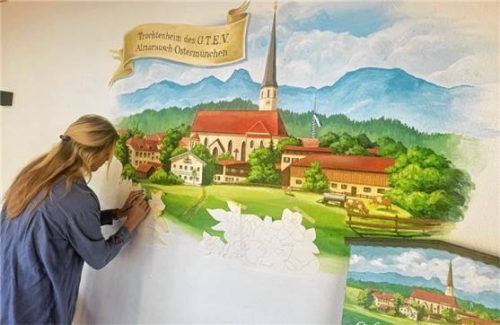 Julia Hörfurter malt das Wandbild. Rechts unten ist das Vereinstaferl als „Vorbild“ zu sehen.