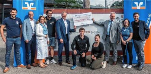 Martin Klampfleitner (Fünfter von links) und Jürgen Ersing (Dritter von rechts) zeigen stolz den Spendenscheck – mit (von links) Michael Mayer, Christian Ellmayer, Katharina Franz, Andreas Schäffer, Felix Spitzenberger, Steffi Stocker, Daniela Rettenberger und Markus Schütz. Foto stache