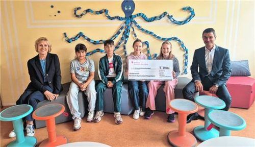 Schulleiterin Sigrid Rechenauer (links) und Thomas Dobner (rechts), Abteilungsleitung Privatkunden der Sparkasse Rosenheim-Bad Aibling, testen gemeinsam mit den Schülerinnen und Schülern des Karolinen-Gymnasium Rosenheim die neuen Sitzgelegenheiten. Foto Sparkasse Rosenheim