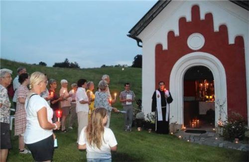 Stimmungsvoll: Pfarrgemeinderat Andreas Beer (Zweiter von rechts) und Kaplan Pater Gabriel-Anton Ferent an der Sailer-Kapelle am Venusberg in Chieming. Foto  Zandl