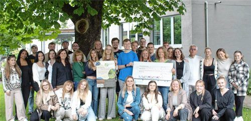 Stolz übergaben die Schüler mit Lehrkräften einen Spendenscheck an Monika Maier vom Landschaftspflegeverband Rosenheim (stehend, Achte von rechts).Foto Romed-Kliniken
