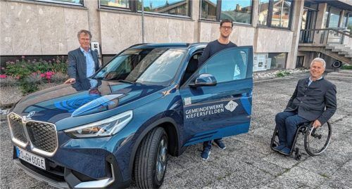 Strahlend präsentieren Bürgermeister Hajo Gruber (rechts), Felix Weiss (Mitte) und Bernhard Holzer (links) das neue E-Auto vor den Gemeindewerken. Foto Hoffmann