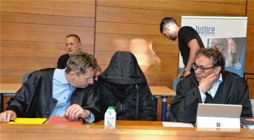 Verdeckt durch die Kapuze ihres Mantels: Die Beschuldigte vor Verhandlungsbeginn zwischen ihren Anwälten Harald Baumgärtl und Alexander Kohut. Foto kretzmer-Diepold