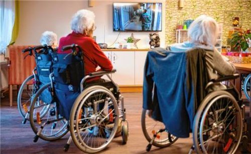 Bewohner eines Senioren- und Pflegezentrums sitzen im Aufenthaltsraum und schauen Fernsehen. Foto dpa