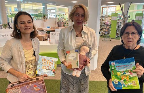 Büchereileiterin Gabriele Huber, ihre Kollegin Brigitte Paul und Heidi Benda, die Vorsitzende des Fördervereins der Stadtbücherei (von links), präsentieren einen Trostkoffer mit dazugehöriger Literatur und Trostengel „Charlie“. Foto Kotter