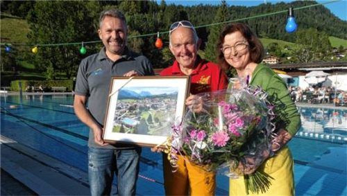Bürgermeister Matthias Schlechter (links) überreichte an Walter und Cilli Wolfenstetter zum Dank für ihre großen Verdienste um das Freibad Reit im Winkl ein Bild davon und einen Blumenstrauß. Foto Hauser