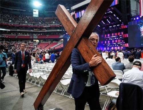 Dan Beazley trägt ein Kreuz bei einer Gedenkfeier für den rechtskonservativen Aktivisten Charlie Kirk im State-Farm- Stadium in Glendale. Foto dpa
