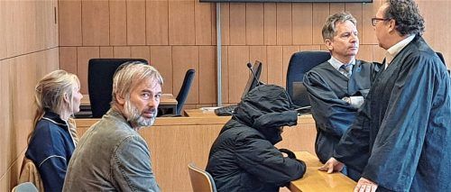 Das Gesicht unter der Kapuze eines Mantels verborgen, nach vorne abgeschirmt durch ihre Wahlverteidiger Harald Baumgärtl und Alexander Kohut: die Beschuldigte kurz vor Beginn der Verhandlung. Foto Weiser