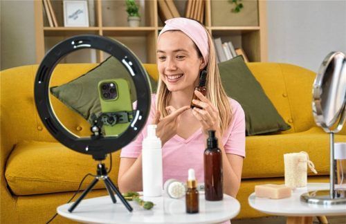 Eine junge Bloggerin zeigt Kosmetikprodukte und nimmt zu Hause Videos auf dem Smartphone auf. Ist das eine realistische Berufsoption? Foto iStock/Getty Images
