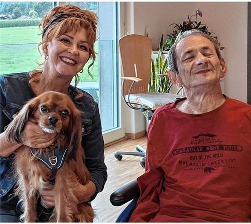 Glücksmomente: Andreas (rechts) fühlt sich wohl in seinem neuen Zuhause. Nach 47 Jahren im „Haus Schonstett“ durfte der 65-Jährige am Dienstag (2. September) sein neues Zuhause in Brannenburg in Besitz nehmen. Begrüßt wurde er im „Haus Christophorus“ auch von Caritas-Regionalmanagerin Petra Schubert und Hündchen Oskar (links). Foto Caritas München-Freising