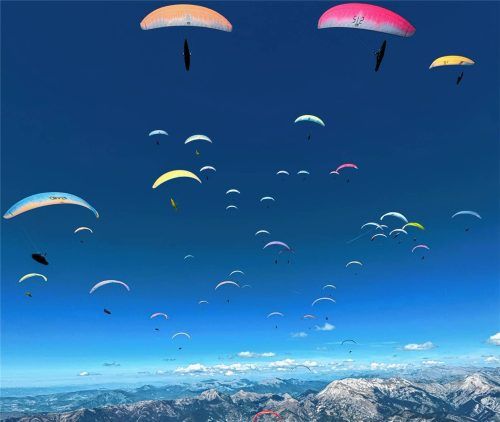 Herausragendes Bild: Die Gleitschirmflieger bei strahlend blauem Himmel über der Bergwelt.Foto re