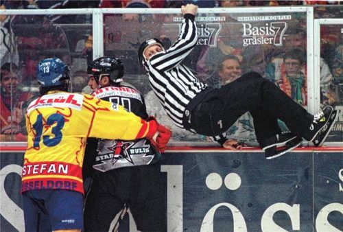 Im Oberhaus ging es zwischen Rosenheim und Düsseldorf manchmal hoch her: Im September 1997 klemmt DEG-Stürmer Leo Stefan den Rosenheimer Tom Bissett an der Bande fest und der Referee musste kurzerhand Reißaus nehmen.Foto Imago