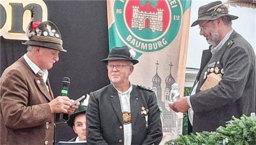 Landesreferent im Bayerischen Sportschützenbund, Franz-Xaver Wagner (links), und Böllerreferent Süd-Ost, Sebastian Hering (rechts), überreichten an Alzgau-Schützenmeister Anton Hochreiter einen Porzellanlöwen.