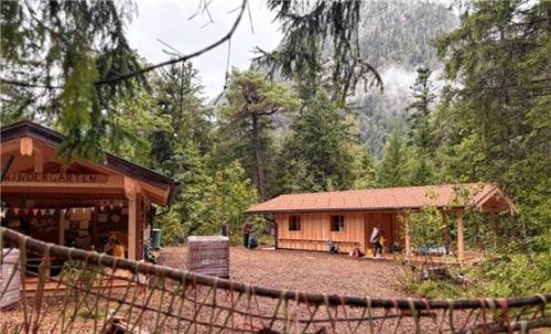 Rechtzeitig zum Kindergartenstart: Die neue Schutzhütte (rechts) auf dem Waldkindergarten-Areal steht. Foto Gemeinde Ruhpolding