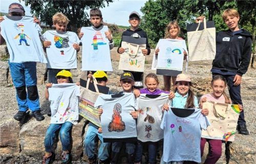Stolz präsentieren die Kinder ihre selbst gestalteten T-Shirts und Taschen. Foto hob