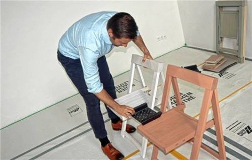 Stühle statt Bänke: Pfarrer Dr. Richard Graupner zeigt hier die Verbindung der Stühle mittels einer kleinen Ablagefläche.