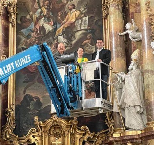 Auf der Hebebühne: (von links) Kirchenpfleger Sebastian Mühlhuber, Diplom-Restauratorin Susanne Dommel und Verwaltungsleiter Christian Staber neben dem gereinigten heiligen Ulrich Bischof von Augsburg. Foto staber