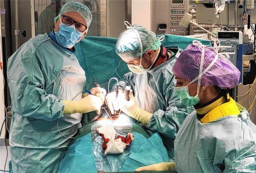 Chefarzt Dr. Roland Rusz (links) am Operationstisch mit Assistenzarzt und OP-Schwester beim Eingriff an der offenen Wirbelsäule in der Schön-Klinik Bad Aibling Harthausen. Foto Schön Klinik Bad Aibling Harthausen/mb (Montage)