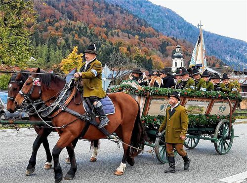 Ein festlich geschmückter Truhenwagen zieht beim 180. Leonhardiritt durch das herbstlich gefärbte Dorf. Im Hintergrund die barocke Kuratiekirche St. Michael, die von den Teilnehmern – wie seit Generationen – dreimal im feierlichen Umritt umrundet wurde. Der Ritt gilt dem heiligen Leonhard als Schutzpatron der Tiere.Foto TI Oberaudorf.